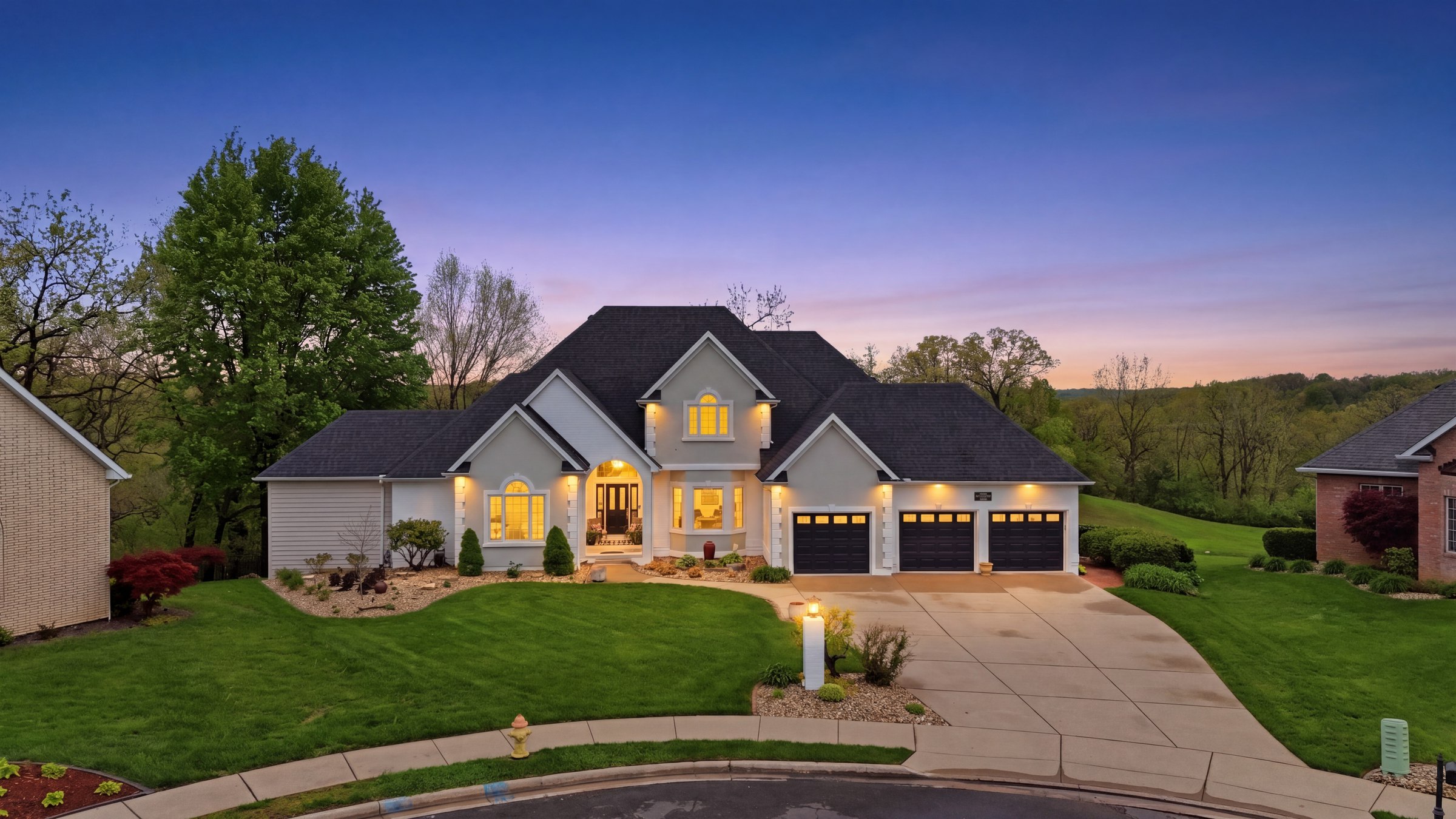 Twilight exterior of a home with lit windows at dusk